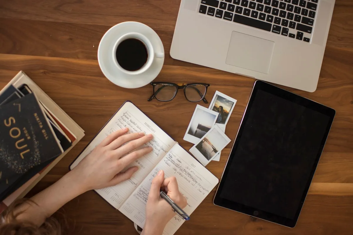 Person taking digital notes on laptop with coffee